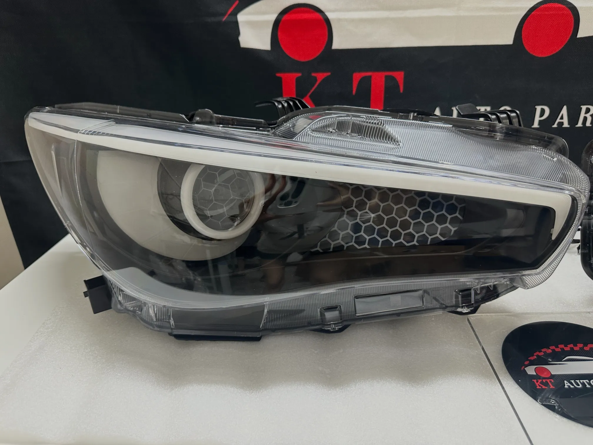 Close-up view of clear lens Infiniti Q50 custom headlight housing showcasing the honeycomb etching design